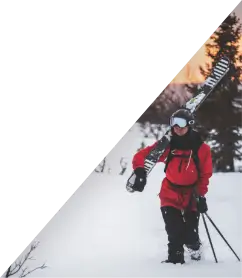 Triangle image of a man skiing in Alberta mountains.